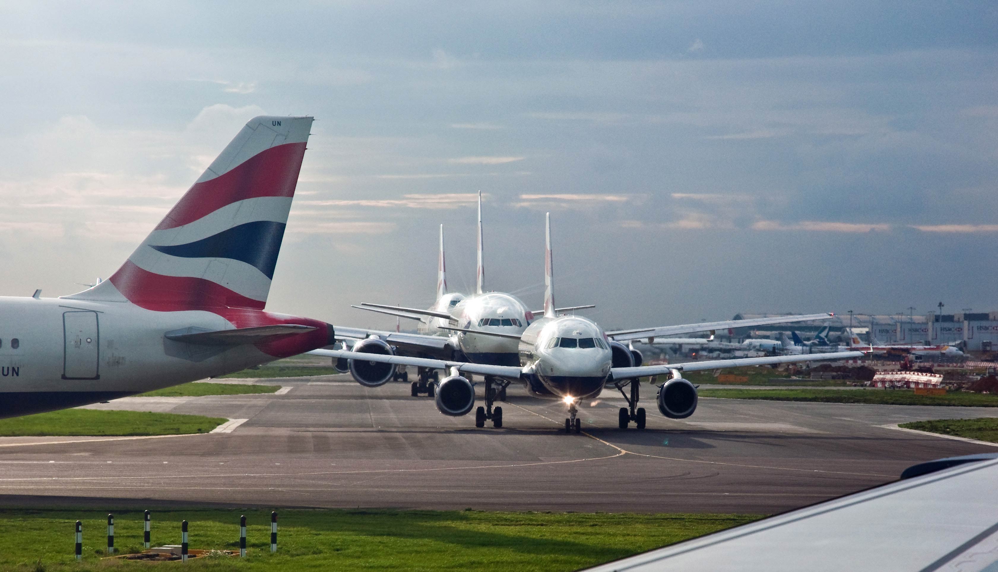 Planes lining up on a runway at Heathrow Airport. 