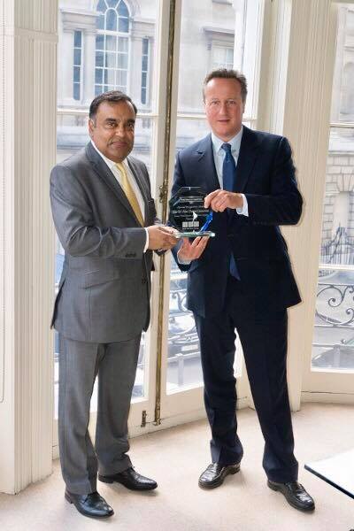 Indian High Commissioner to UK Y K Sinha presents a 'Special Recognition Award' to former British PM David Cameron.