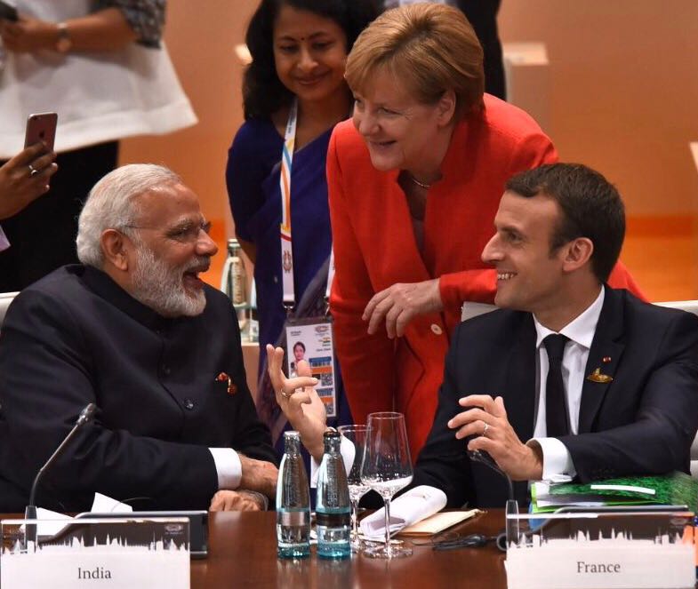 Modi (left) interacting with German Chancellor Angela Merkel (centre) and French President Emmanuel Macron during a panel discussion.