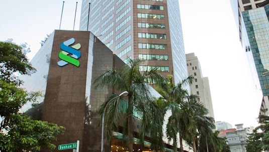 Raffles Place Office Building with Standard Chartered logo in Singapore.