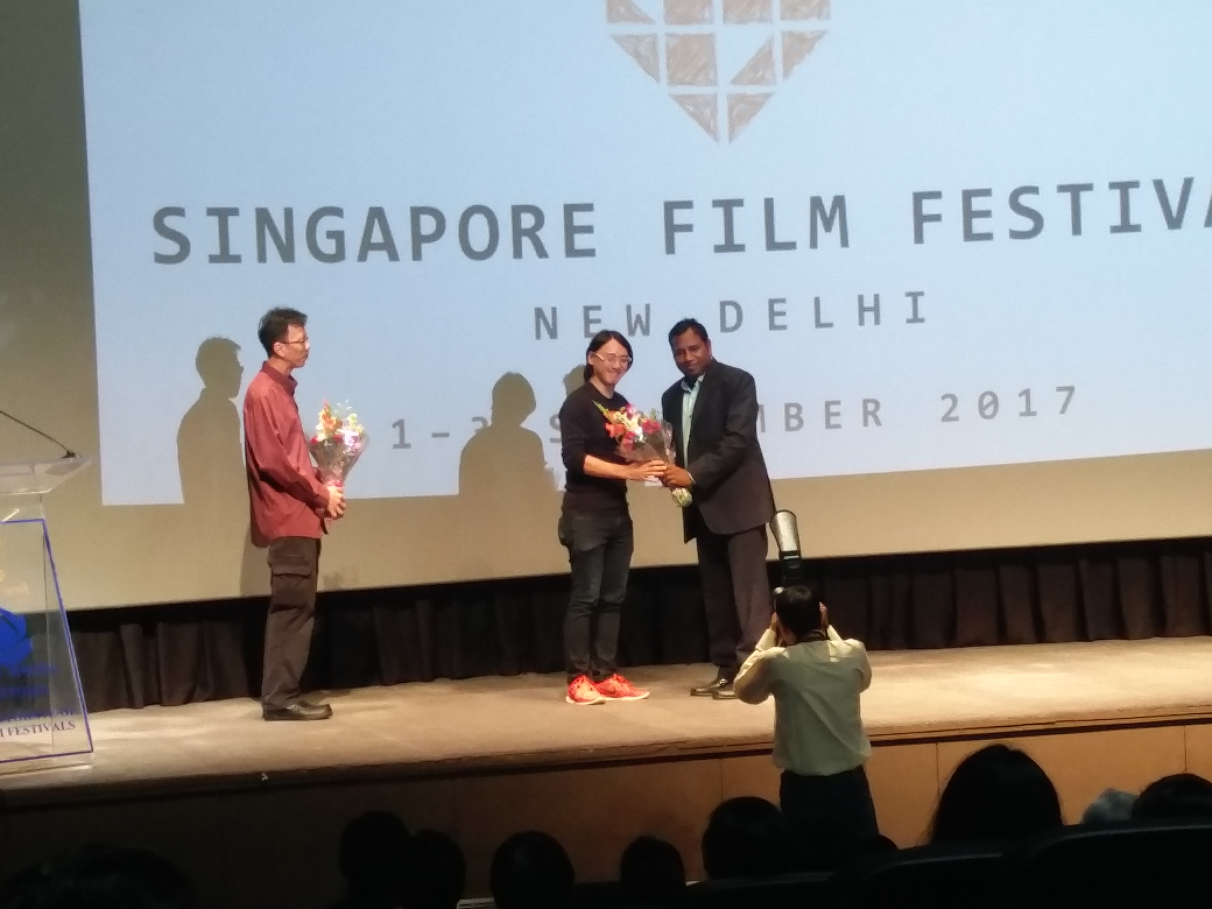 DFF director felicitating 'That Girl in a PInafore' director Yee Wei Chai, as music producer, Zennon Goh looks on.