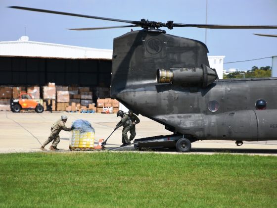 Airmen from the Republic of Singapore Air Force (RSAF) working closely with soldiers from the Texas Army National Guard (TXARNG) to load supplies onto the RSAF's CH-47 Chinook helicopter