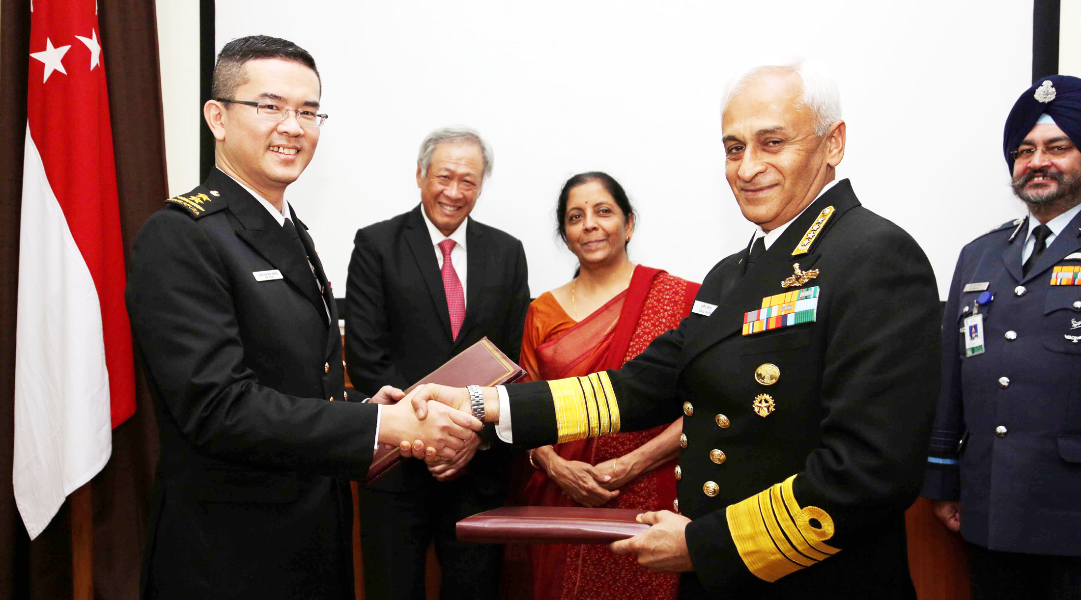 The Chief of Naval Staff, Admiral Sunil Lanba exchanging the signed documents of bilateral agreement with the Naval Chief of Singapore Rear Admiral Lew Chuen Hong, in the presence of Indian Minister for Defence, Nirmala Sitharaman, and the Defence Minister of Singapore, Dr. Ng Eng Hen, in New Delhi on November 29, 2017. The Chief of the Air Staff, Air Chief Marshal B.S. Dhanoa is also seen. (Photo courtsey: Press Information Bureau)