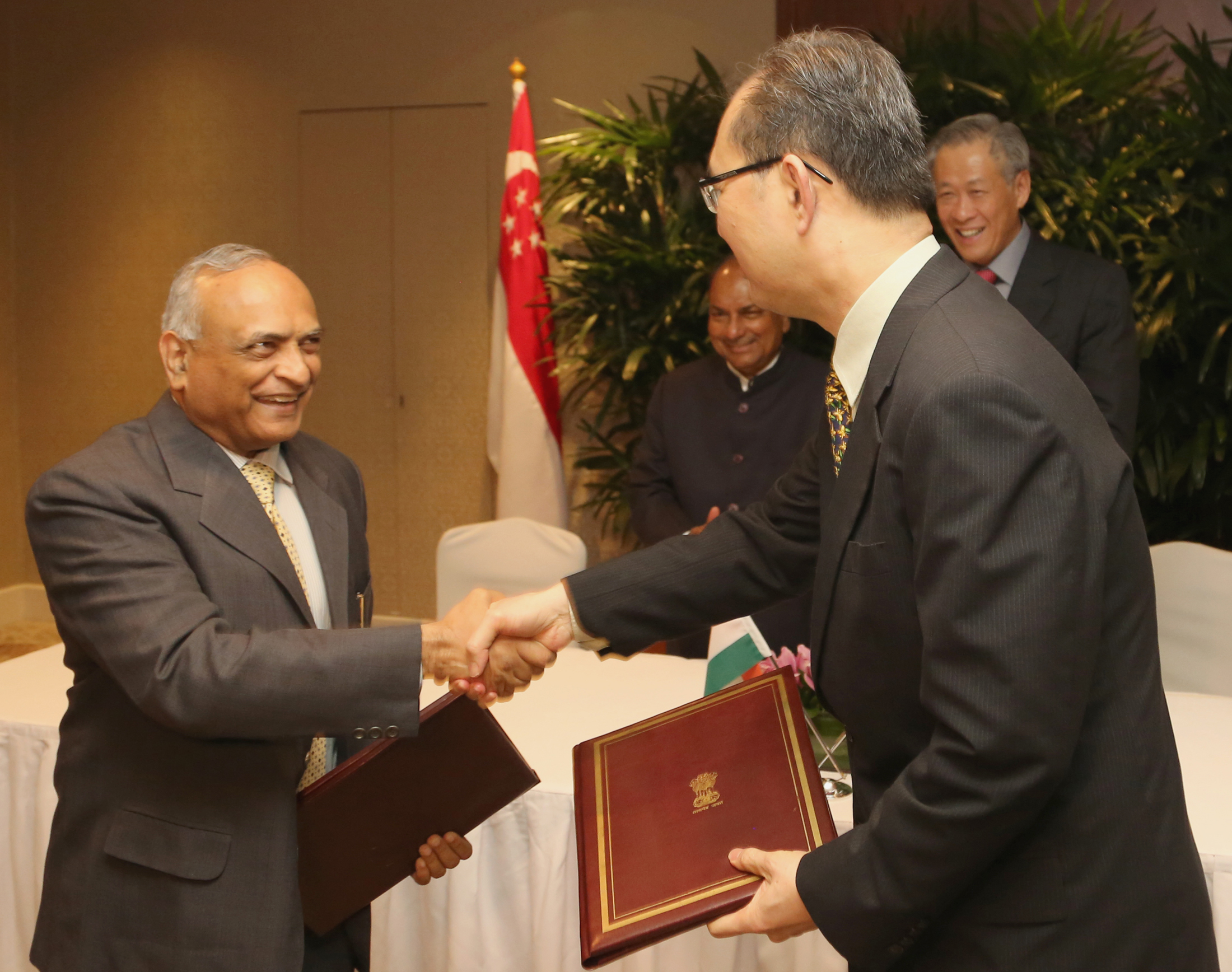 The Indian Defence Secretary, Radha Krishna Mathur and Singaporean Permanent Secretary of Defence, Chiang Chie Foo exchanging the signed documents of an agreement to extend the use of training and exercise facilities in India by the Singapore Army for a further period of five years from August this year, in the presence of the Defence Minister, A. K. Antony and his Singaporean counterpart Dr. Ng Eng Hen, in Singapore on June 03, 2013.