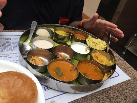 An amalgamation of flavours ranging from spicy to sweet, the thali comprises of rasam, plain rice, curd, badam payasam, sambar, poriyal (curry), kootu etc