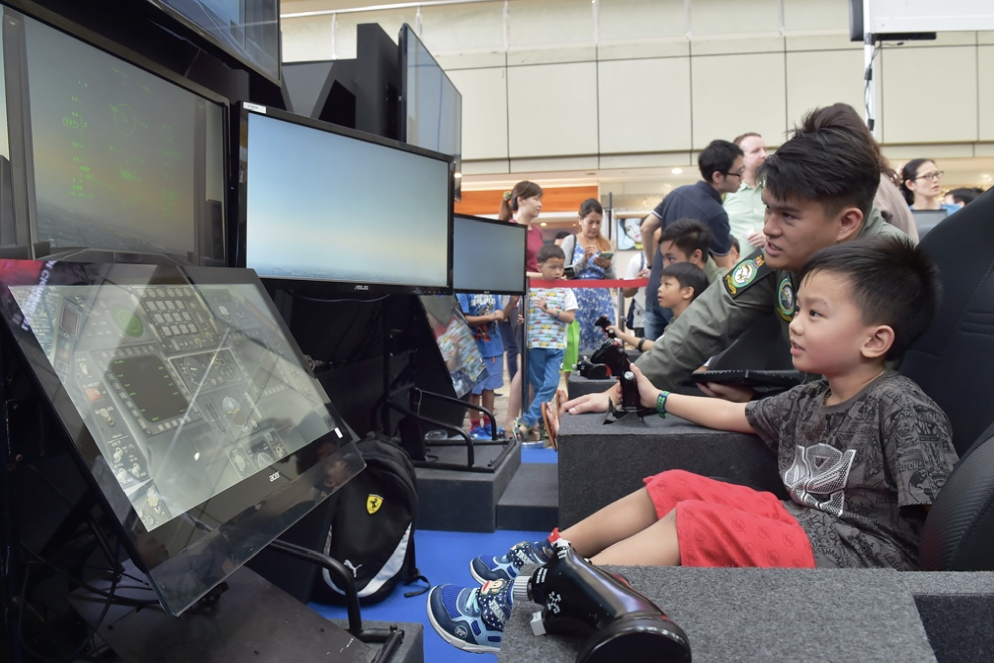 An RSAF serviceman interacting with a visitor at the flight simulator at RSAF50@Heartlands. Photo courtesy: Mindef