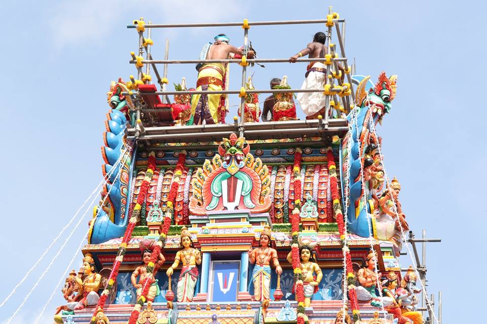 Priests pouring holy water on the temple pinnacles to re-sanctify the deities. The water was drawn from nine holy rivers in India and brought to Singapore. The priests have been praying twice a day for for the last six days in preparation for the consecration. 