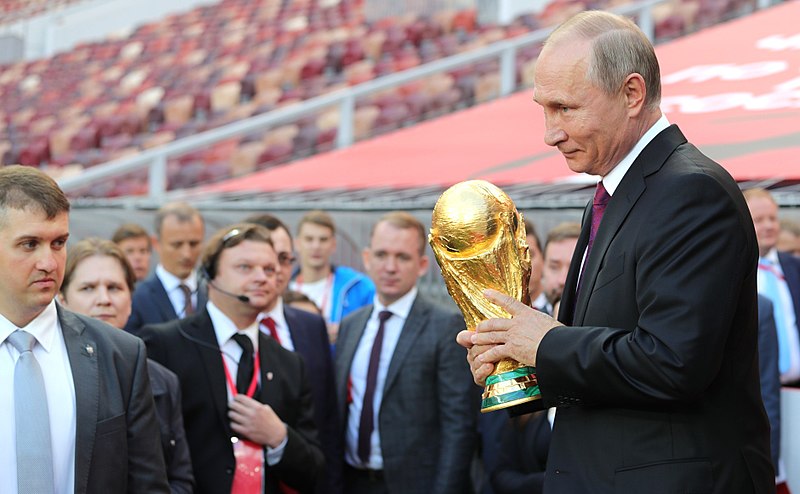 Russian president Vladimir Putin holding the FIFA World Cup Trophy at a pre-tournament ceremony in Moscow in September 2017. Photo courtesy: Wikimedia 