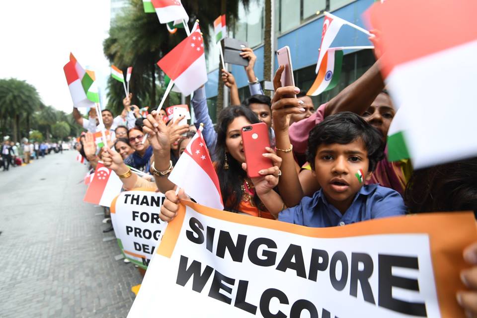 People of Indian community waving Indian and Singaporean flags to welcome Indian Prime Minister Narendra Modi.