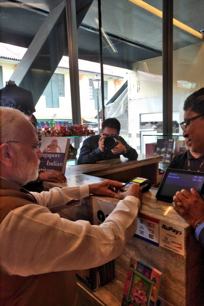 PM Modi purchasing a Madhubani painting using a RuPay card at Indian Heritage Centre. 