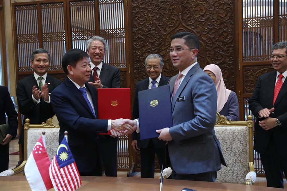 Transport Minister of Singapore Khaw Boon Wan and Malaysian Economic Affairs Minister Azmin Ali shake hands after signing the agreement to suspend the Kuala Lumpur-Singapore High Speed Rail Project to 31 May 2020, in the presence of Malaysian PM Dr Mahathir, DPM Dr Wan Azizah, Transport Minister Anthony Loke, DPM of Singapore Teo Chee Hean and Foreign Minister of Singapore Vivian Balakrishnan. With this, the HSR Express Service will now commence in January 2031 instead of the original date of 31 December 2026. Photo courtesy: Facebook page of Khaw Boon Wan