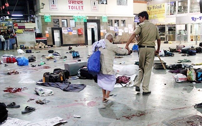 Policeman helping an old man across platform littered with victims belongings at Mumbai railway station just after the terror attack on 26 November 2008 (Photo courtesy: Daniel Carmon, Twitter