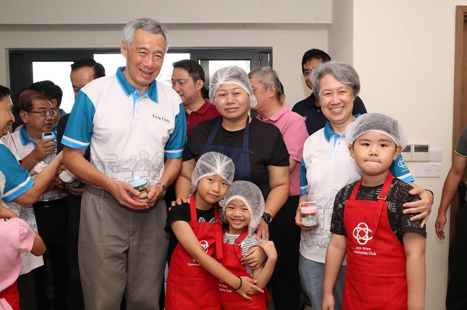 PM Lee received a jar of butter cookies from little bakers Chloe and Jervelle (centre), who looked very adept despite their young age. Photo courtesy: Facebook page of PM Lee