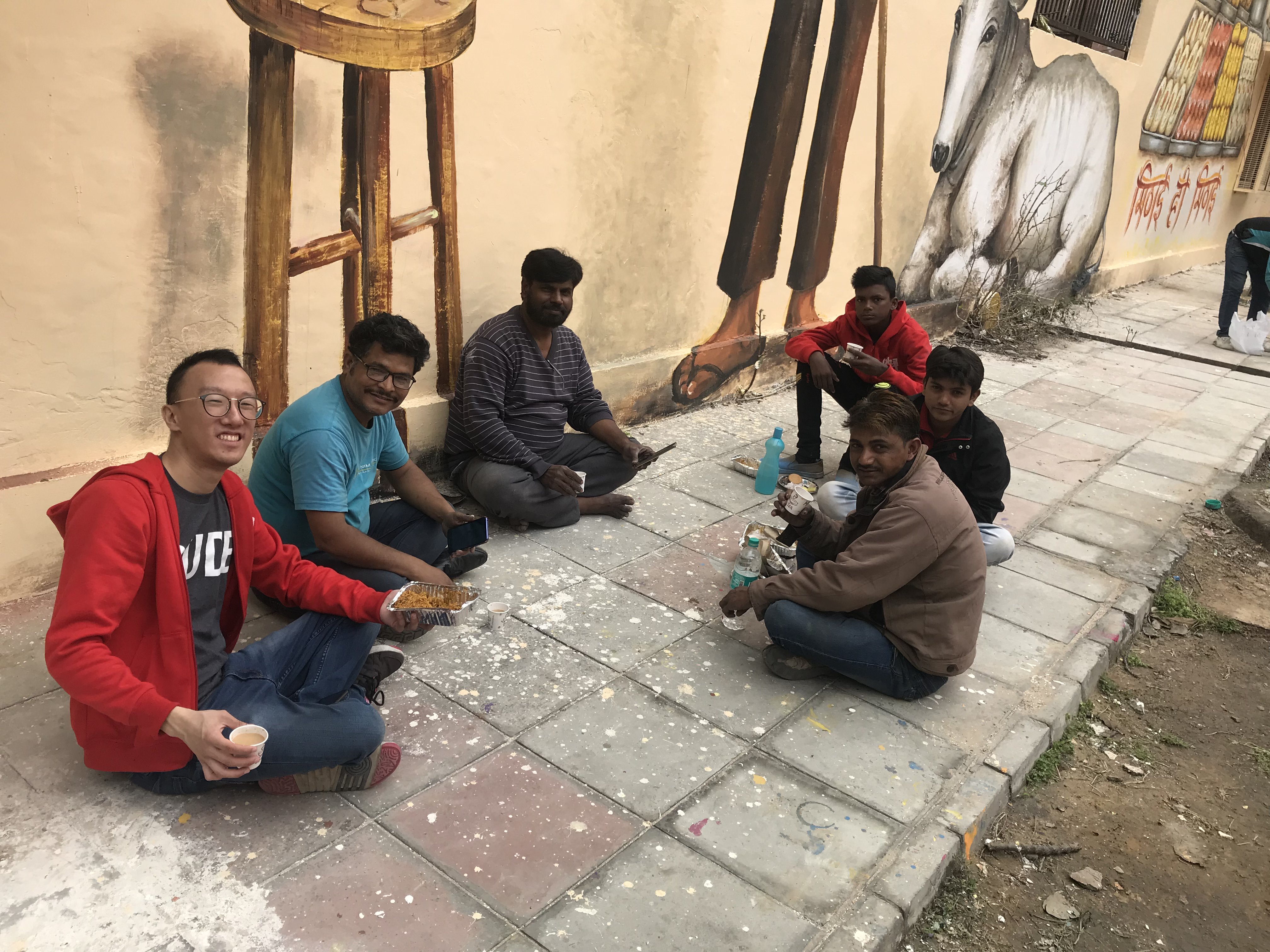 Eugene (left) shares a lunch break with Indian street artists in Lodhi Colony. Photo: Connected to India