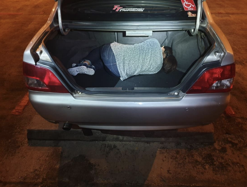 The Myanmar national hiding in the boot of a car. Photo courtesy: ICA