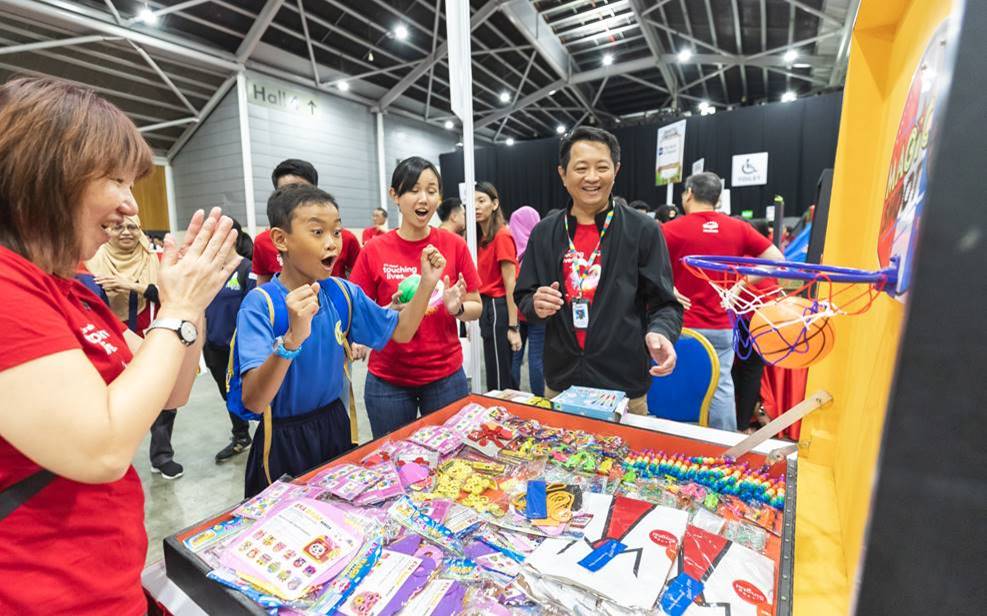 Special needs students having a ball of a time at the Singtel Carnival with Singtel staff volunteers. Photo courtesy: Singtel