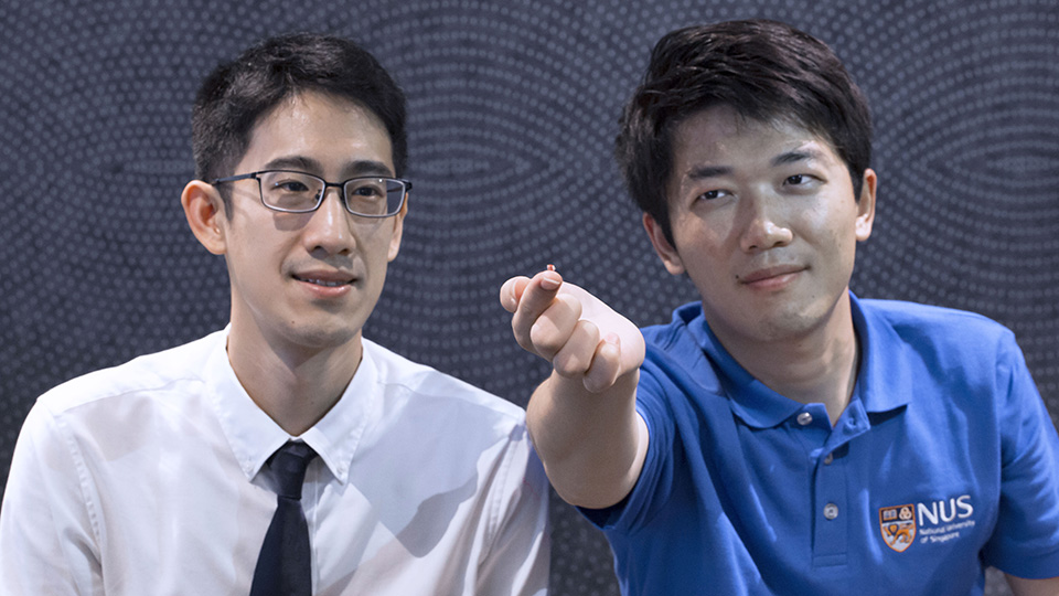 The advanced wireless technology developed by Assistant Professor John Ho (left) and doctoral student Dong Zhenya (right) can sense implantable microsensors. One of the microsensors is shown on the finger of Dong. Photo courtesy: NUS