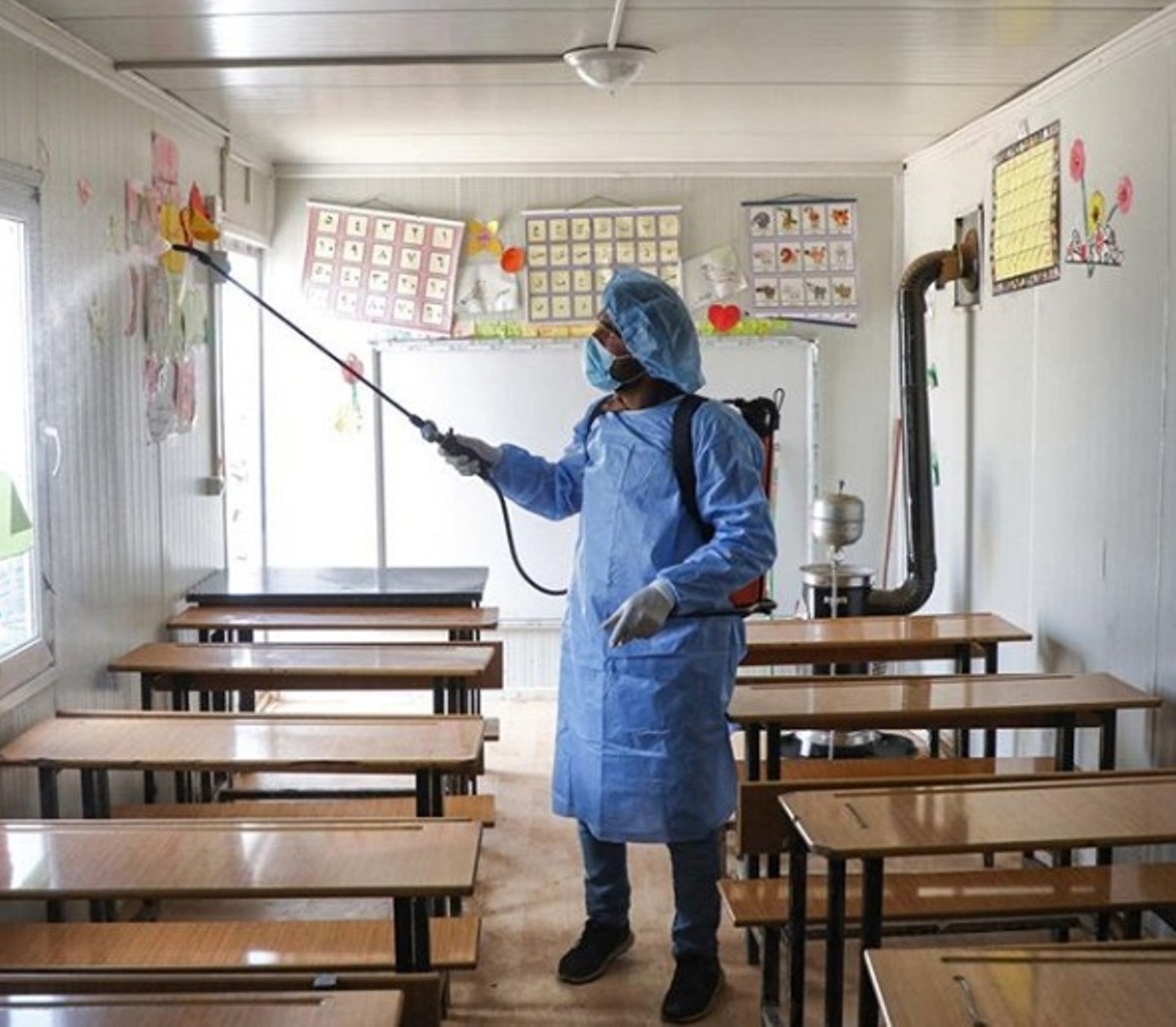 A volunteer disinfecting a make-shift classroom at a camp for displaced people in Idlib, Syria. Photo courtesy: Instagram/unicef