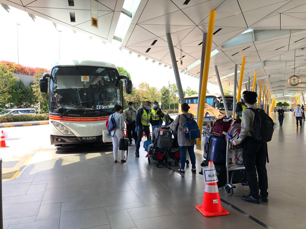 Passengers boarding the bus on the way to serve their SHNs. Photo courtesy: Changi Airport