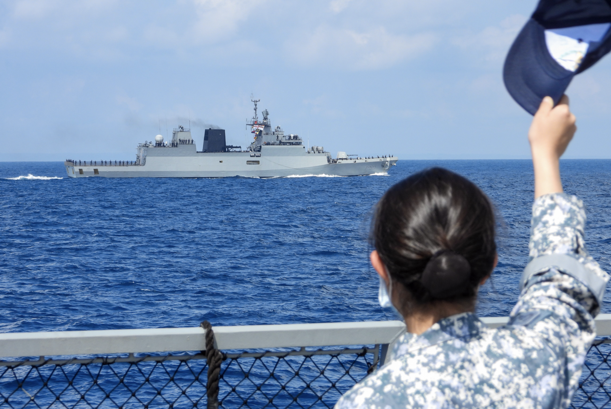 RSN sailor waving at sailors from INS Kamorta as SIMBEX 2020 concludes. Photo courtesy: Mindef