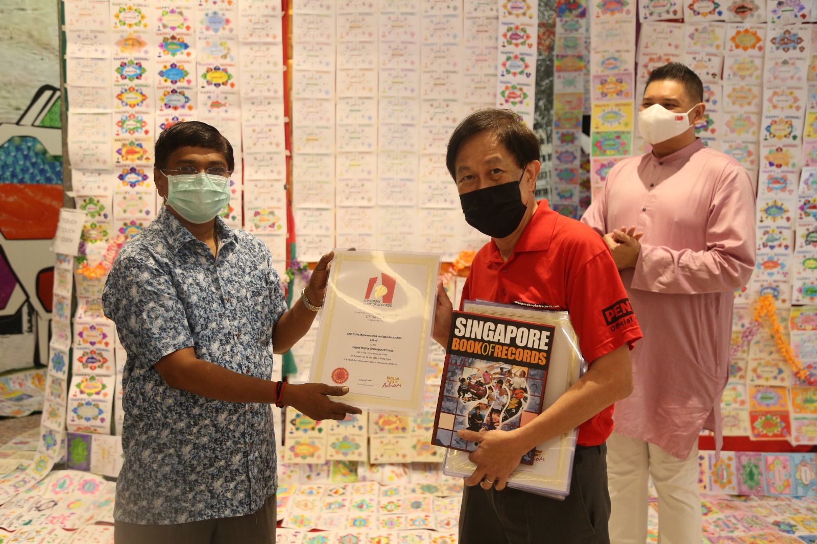 Little India Shopkeepers & Heritage Association (LiSHA) chairman Rajakumar Chandra receives the certificate from the official record keeper for the Singapore Book of Records. Photo Courtesy: SingaRangoli 