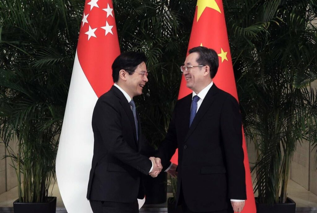 Lawrence Wong (left) shakes hand with Ding Xuexiang.