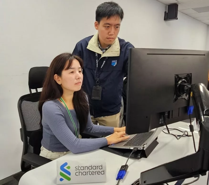 Palkim Mao (left) and DSP Timothy Ng (right) working on a case to prevent more than SGD 50,000 loss from an investment scam victim. Photo courtesy: SPF