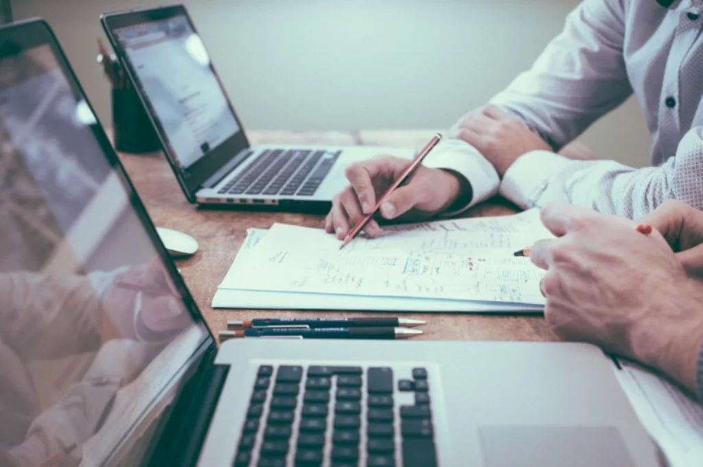 Employees diligently work on a laptop, focused on streamlining billing and collection processes to prevent revenue leaks within the organisation. Photo courtesy: Collected