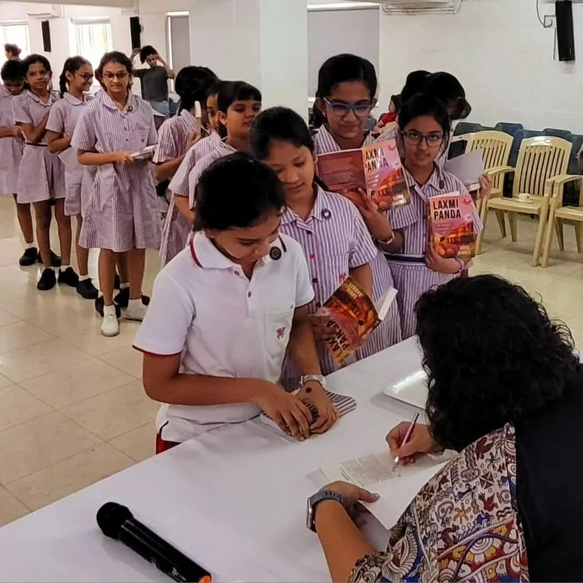 Savie Karnel signs her book on Laxmi Panda
