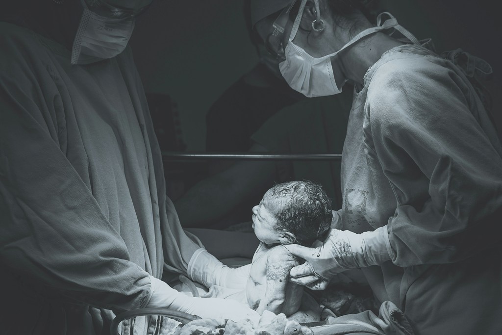 Doctors delivering a baby. Representational image. Photo courtesy: Unsplash