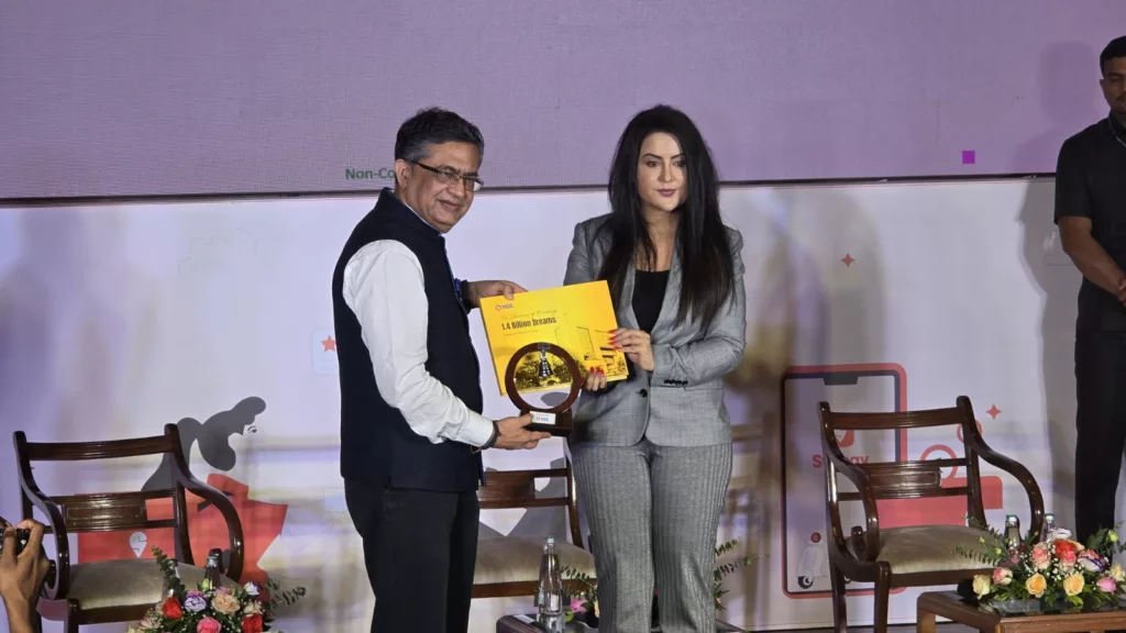 NSE MD and CEO, Ashish Chauhan (left)
presenting the NSE Coffee Table Book and the NSE Bell to Amruta Fadnavis. Photo courtesy: x.com/NSEIndia