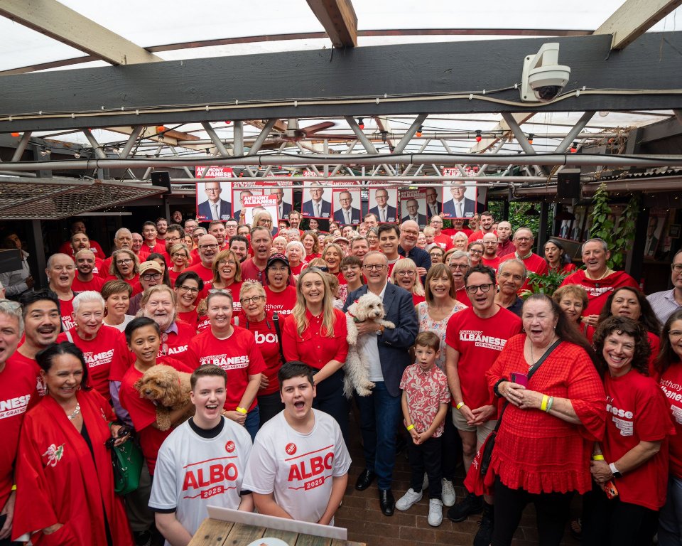 Australian Prime Minister Anthony Albanese (centre, holding the dog) pose for a picture with volunteers. Photo courtesy: x.com/AlboMP